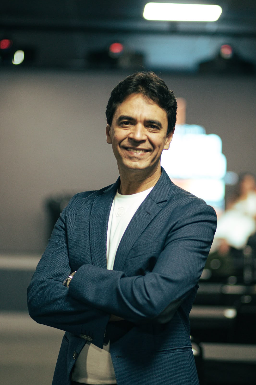 Márcio Manzi, planejador financeiro e palestrante, de braços cruzados olhando para a câmera